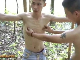 Adorable Asian lad finds himself in the woods, tied up and at the mercy of a muscular hunk. The lad skillfully works his magic on the hunk's throbbing manhood, culminating in a steamy, outdoor climax.