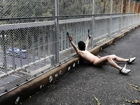Japanese exhibitionist men, Takehito and friends, bask in the sun on a pedestrian bridge, uninhibited and free. This daring daytime escapade pushes the boundaries of nudity and exposure, offering an exhilarating experience.