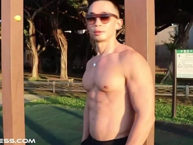 A chiseled Asian hunk flaunts his sculpted physique in an outdoor workout, showcasing his muscular back, bulging biceps, and a visible six-pack. A feast for muscle worship enthusiasts.